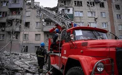 Menschen stehen unter den Trümmern eines Hauses in Sloviansk